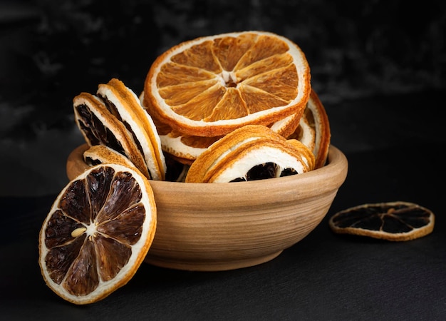 A closeup photo of dried lemon and orange slices in a cup