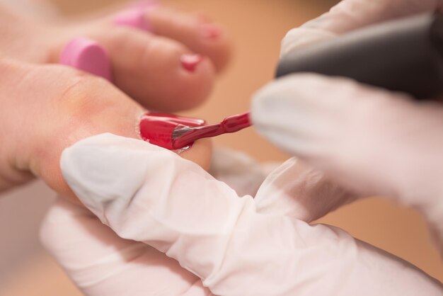 Closeup photo of a female feet at spa salon on pedicure and manicure procedure