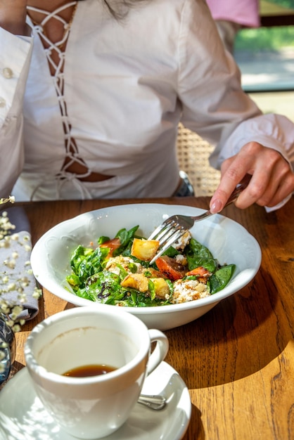 Closeup photo girl eats salad at restaurant