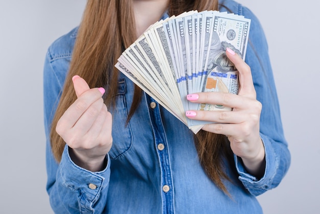 Closeup photo portrait cropped view of happy satisfied independent confident smiling she her lady student manager boss employee enjoying lot many pile of money isolated grey background