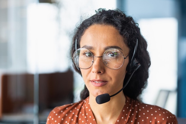 Closeup photo portrait of a young beautiful latin american woman in a headset call center service