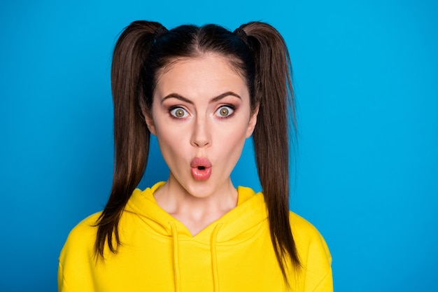 Closeup photo of pretty terrified lady funny two tails hairdo open mouth watch news quarantine continue wear casual yellow sweatshirt pullover isolated bright blue color background