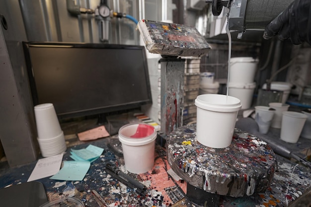 Closeup photo of table with scales computer and paint cans Place for mixing paint and color matching