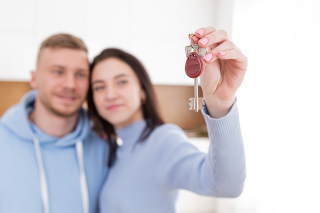 Closeup photo of thorns from the apartment door, a woman holding the keys to a new apartment