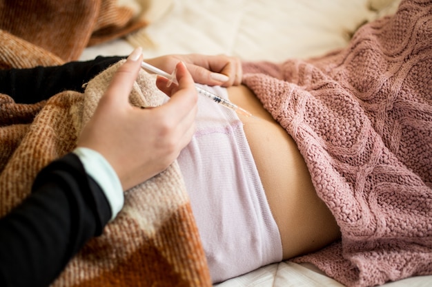 Closeup photo of woman making injection in sick child's bottom