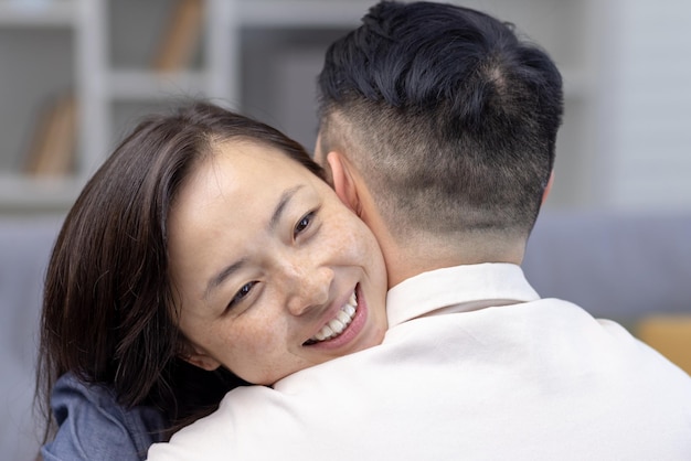 Closeup photo young asian couple family hugging together happy face of young woman hugging and