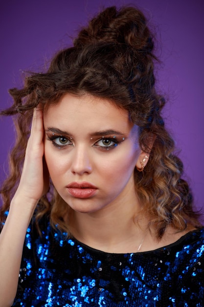 Closeup photo of young lady put her hand to her face and looking at the camera High quality photo