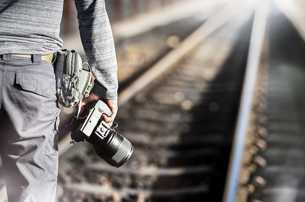 Closeup photography holding on professional Camera with copy space on train station.