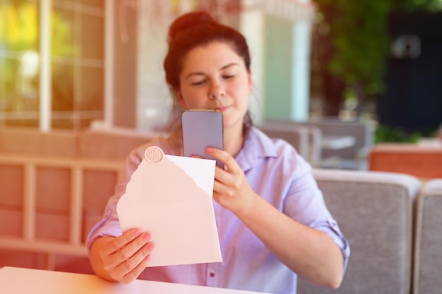 Closeup photography of womanmaking photography of invitation envelope with wax seal and blank cards