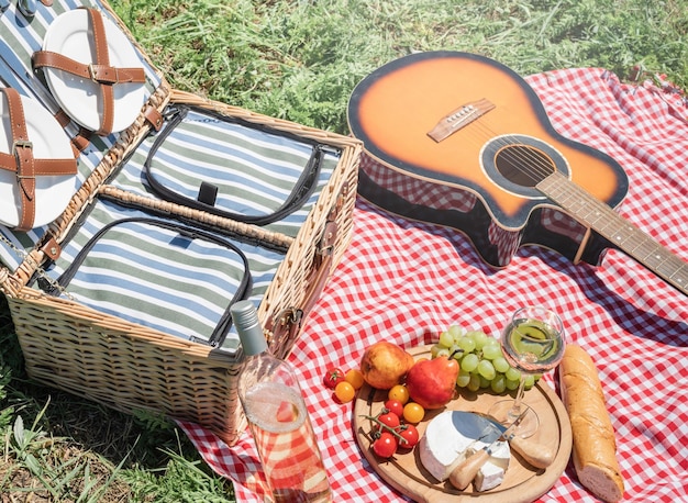 Closeup of picnic basket with drinks and food on the grass