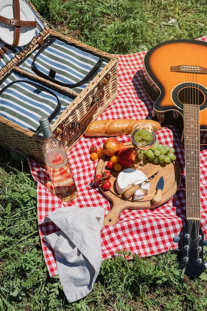 Closeup of picnic basket with drinks and food on the grass