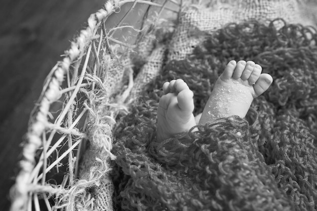 Closeup picture of newborn baby feet on knitted plaid