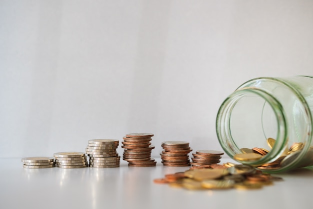 Closeup pile coins with bottle on white background 