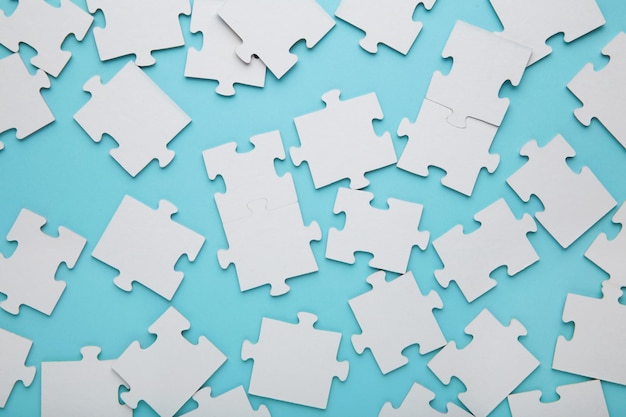 Closeup of a pile of uncompleted elements of a white puzzle A huge number of rectangular pieces from one large white mosaic