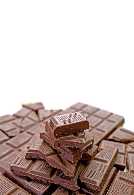 Closeup of piled up dark chocolate chunks on white backdrop