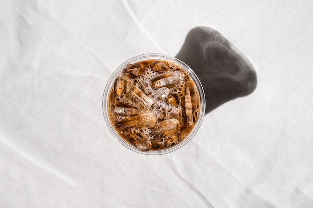 Closeup plastic cup of iced coffee with milk on the table