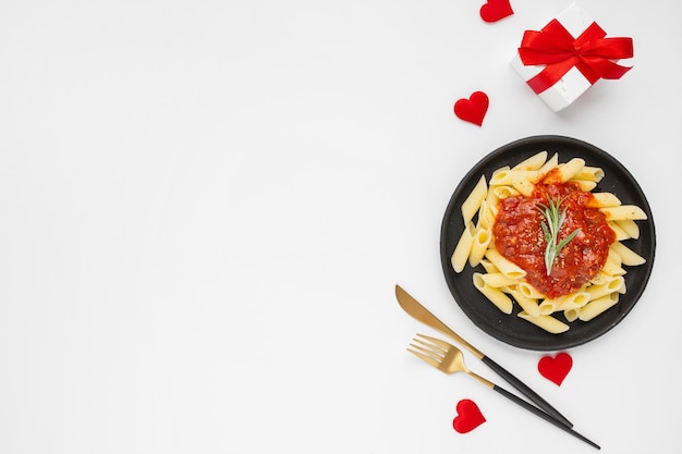 Closeup of a plate of pasta and a gift- concept Valentine's day celebration