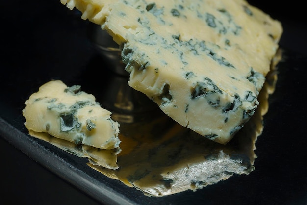 Closeup of the pores and texture of a piece of cheese with blue mold