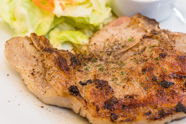 Closeup of pork pepper steak with vegetable on white plate