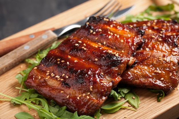 Closeup of pork ribs grilled with BBQ sauce.