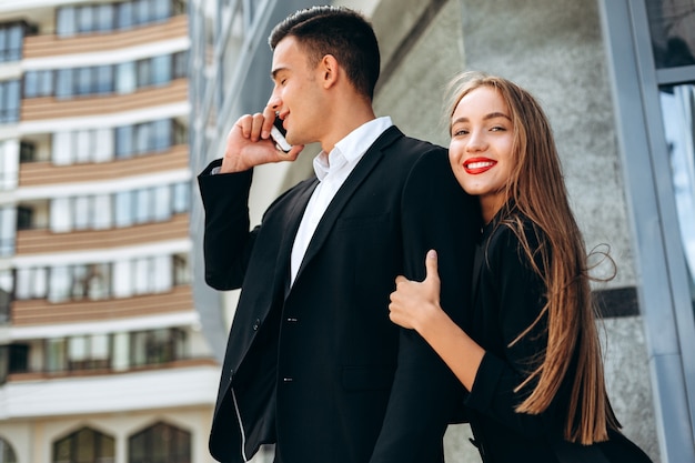 Closeup portrair woman hugging a man who talking a mobile phone.- Image