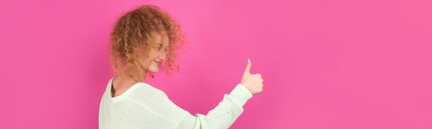 Closeup portrait of attractive surprised girl showing thumbs up gesture Success luck concept