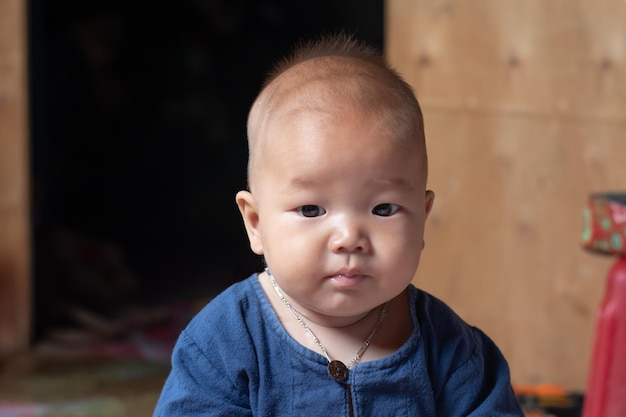 A closeup portrait of baby boy sit on the floor and looking camera infant and newborn happiness concept copy space for individual text