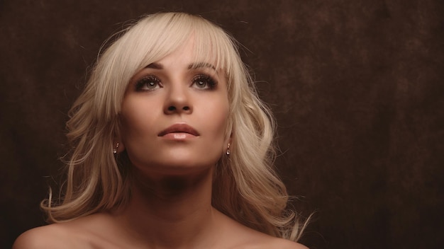 Closeup portrait of a beautiful blonde girl looking up