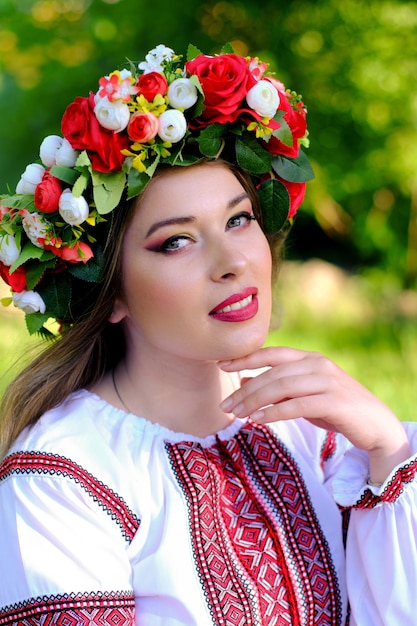 Closeup portrait of a beautiful Ukrainian girl in a traditional dress and a wreath on her head Vertical image