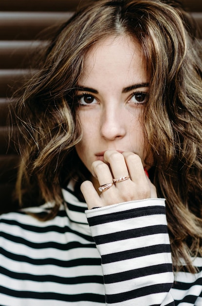 Closeup portrait of a brunette young woman with brown eyes and wavy hair