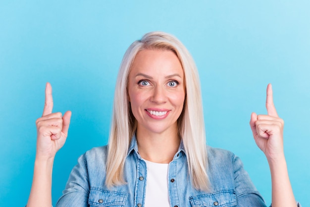 Photo closeup portrait of business woman directing fingers up empty space isolated blue background