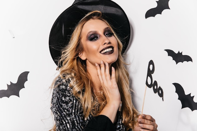 Closeup portrait of charming european woman in wizard hat Indoor photo of lovely girl celebrating halloween