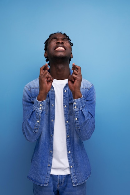 Closeup portrait of an energetic explosive young stylish american guy with dreadlocks in a denim