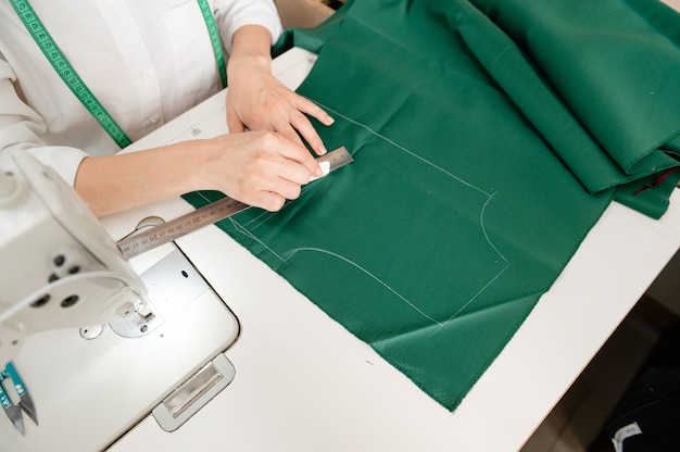 Closeup portrait of experienced tailor sewing clothes in tailor shop