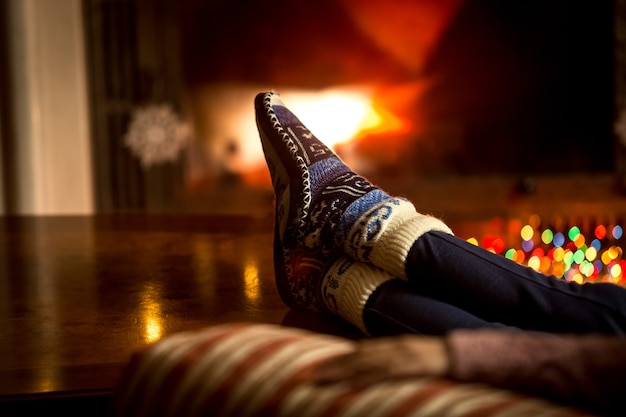 Closeup portrait of feet at woolen socks warming at fireplace in winter