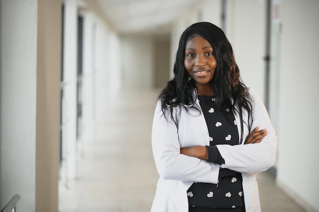 Closeup portrait of friendly, smiling confident female healthcare professional with lab coat, stethoscope. Isolated hospital clinic background. Time for an office visit