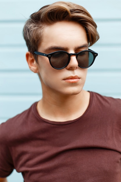 Closeup portrait of a handsome man with the hairstyle in sunglasses