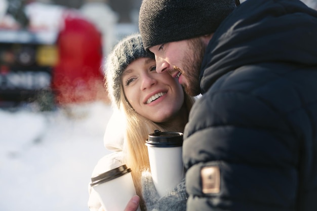 Closeup portrait of a happy couple men and women hugging and laughing in a winter snow park