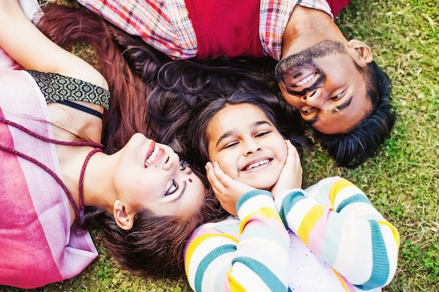 closeup portrait of indian family lying down on a grass