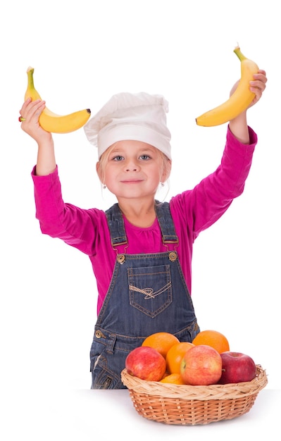 Closeup portrait of a little girl holding fruits apples bananas and oranges Isolated on a light background