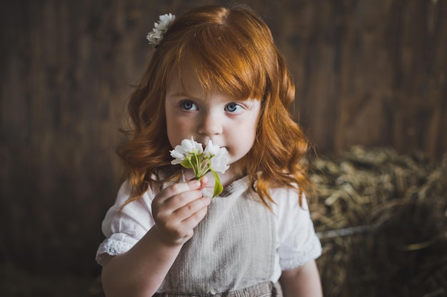 Closeup portrait of little girl with red hair and flower 6144