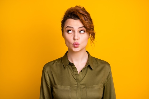 Closeup portrait of lovable cute curious girl sending air kiss looking aside