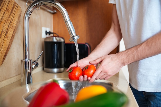 Closeup portrait of a male hands washing vegetables