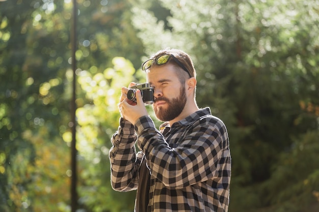 Closeup portrait man photographer taking picture with vintage camera on city green park leisure activity and hobby concept