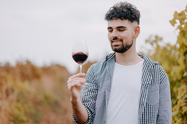 Closeup portrait of a man with a glass of red wine Winery harvesting and organic production of wine