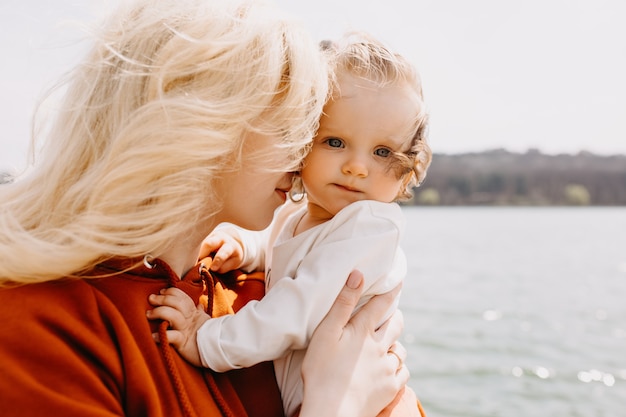 Closeup portrait of mother and little girl hugging outdoors