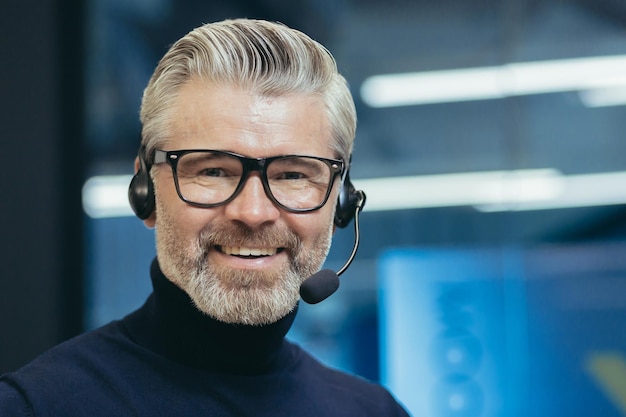 Closeup portrait of senior mature boss with headset video call man smiling and looking at camera