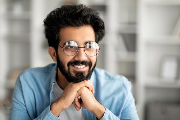 Closeup portrait of smiling handsome indian guy wearing eyeglasses