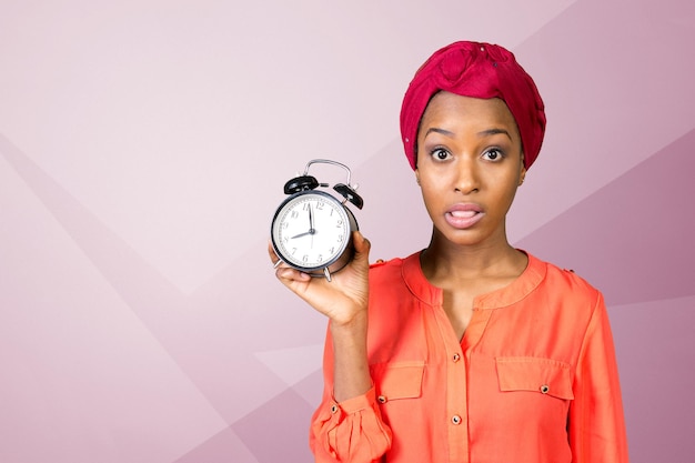 Closeup portrait of a stressed woman holding, looking anxiously at a clock