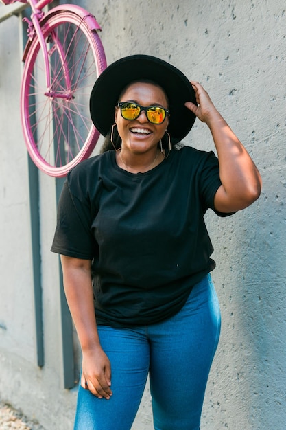 Closeup portrait stylish young African American girl with curly hair in fashionable sunglasses in urban with copy space and place for advertising summer hipster photos with instagram style